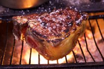 Un steak salé sur un gril — Photo de stock
