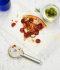 A slice of pepperoni pizza with a bowl of green olives — Stock Photo