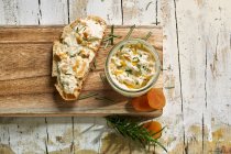 Fromage à la crème aux abricots et romarin dans un bocal et sur une tranche de pain — Photo de stock
