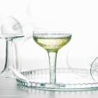 Copa de champán burbujeante bebida con vasos vacíos - foto de stock