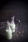 Домашнее фисташковое молоко с соломинками в бутылках — стоковое фото