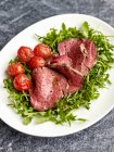 Tagliata di Manzo (beef fillet on a bed of rocket with cocktail tomatoes, Italy) — Stock Photo