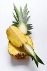 A half and a quarter slice of pinapple against a white background — Stock Photo