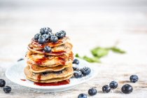 Blueberry pancakes with blueberries and maple syrup — Stock Photo