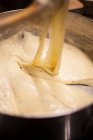Повар готовит сырный соус для приготовления макаронного сыра — стоковое фото