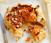 Crostata peaches and with almonds, cut piece and knife — Stock Photo