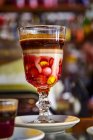 Una bebida de cacao con granos de chocolate servidos en un vaso de tallo decorativo - foto de stock