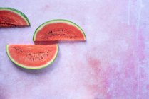 Wassermelonenscheiben auf rosa Steinoberfläche — Stockfoto