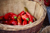 Rote Paprika in einem Korb auf einem Marktstand — Stockfoto