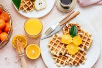 Homemade waffles with orang juice, top view — Stock Photo