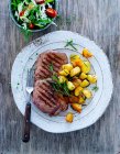 Steak croustillant avec pommes de terre au romarin et salade de jardin — Photo de stock