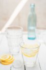 Acqua fresca in un bicchiere con cubetti di ghiaccio e fette di limone — Foto stock