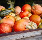 Different pumpkins on a wooden cart — Stock Photo