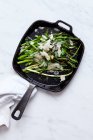Green asparagus with parmesan in a pan — Stock Photo