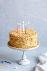 Honey cake with burning candles for birthday — Stock Photo
