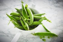 Green peas in a bowl on a gray background — Stock Photo