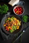 Espaguete amarelo e verde com um molho de tomate e bacon colorido — Fotografia de Stock