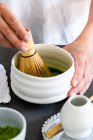 Fouetter le thé matcha avec un fouet de bambou — Photo de stock