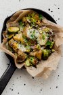 Patatas y coles de Bruselas en papel pergamino - foto de stock