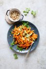 Carrot tagliatelle with roasted pine nuts — Stock Photo
