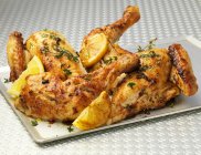 Roast chicken with lemon and herbs - foto de stock