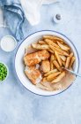 Рыба и чипсы - жареная треска, картошка фри, зеленый горох и соус тартар — стоковое фото