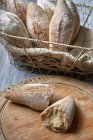Sourdough bread rolls spilling out of basket — Stock Photo