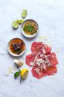 Beef carpaccio with different dressings — Stock Photo