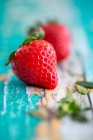 Mehrere Erdbeeren auf türkisfarbenem Holzgrund — Stockfoto