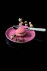 Macaron rosa con capullos de rosa secos - foto de stock
