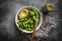 Ensalada verde saludable con espinacas, coles de Bruselas, aguacate en tazón y batido verde de desintoxicación - foto de stock