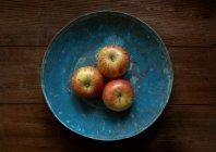 Manzanas en un bol de cobre azul - foto de stock