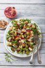 Pear, salad with gorgonzola cheese, pomagranate seeds, rocket, walnuts, walnuts and half of pomegranate — Stock Photo