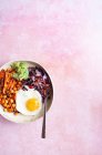 Ciotola Buddha con uovo fritto, patate dolci al forno, ceci piccanti, insalata di cavolo rosso e guacamole — Foto stock