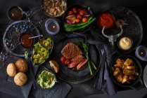 Steak de bœuf grillé avec divers plats d'accompagnement — Photo de stock