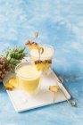 Cocktail alcolici con succo d'ananas fresco e fette con bastoncini in bicchieri — Foto stock