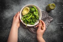 Зелений здоровий салат зі шпинатом, брюссельськими паростками, авокадо в мисці та зеленим детоксикаційним смузі — стокове фото