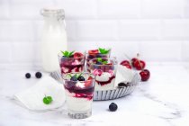 Small glasses with mascarpone cream and egg-free cream with cherries and blackberrie — Foto stock
