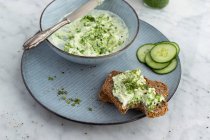 Wild garlic sheep's cheese cream on wholemeal bread with cucumber slices — Stock Photo