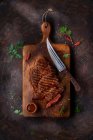 Grilled steak on a ceramic and wood board on marble table — Stock Photo