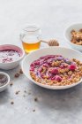 Müsli mit Beerenjoghurt, Honig, Chiasamen, Himbeersoße und frischen Himbeeren — Stockfoto