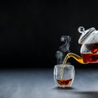 Nahaufnahme von köstlichem Einschenken von schwarzem Tee, dampfend — Stockfoto