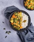 Bohnen-Kartoffel-Curry mit Reis in Schüsseln auf dem Tisch — Stockfoto