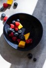 Bunter Obstsalat mit Mangostücken, Himbeeren und Blaubeeren — Stockfoto