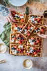 Hände nehmen Waffeln mit Erdbeeren, Blaubeeren und Schlagsahne vom Tisch — Stockfoto