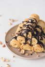 Crepes with chocolate sauce and hazelnuts — Stock Photo