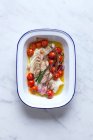 Baked cod fish with cherry tomatoes, garlic and herbs — Stock Photo