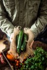 Un agricultor que tenga calabacines recién cosechados - foto de stock