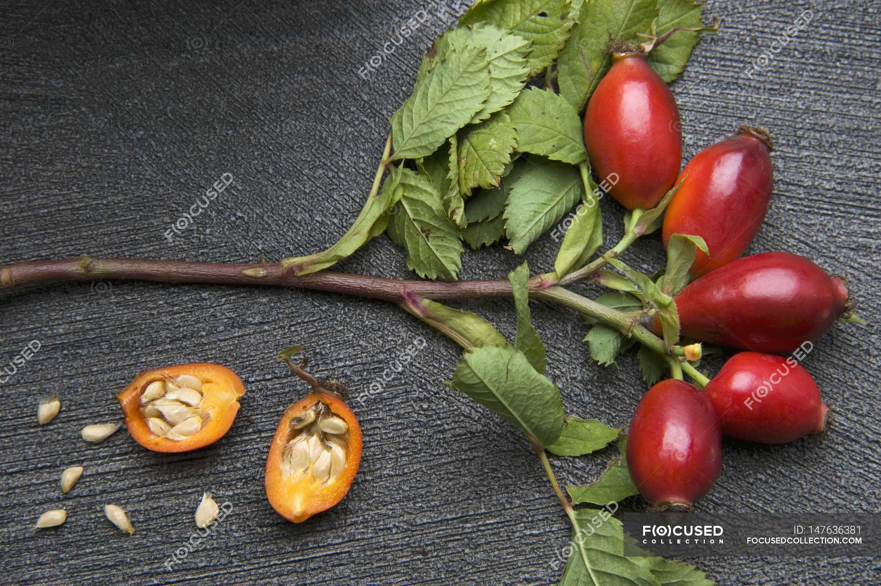 Closeup View Of Sprig Of Rose Hips And A Halved Rose Hip Flavour Colors Stock Photo