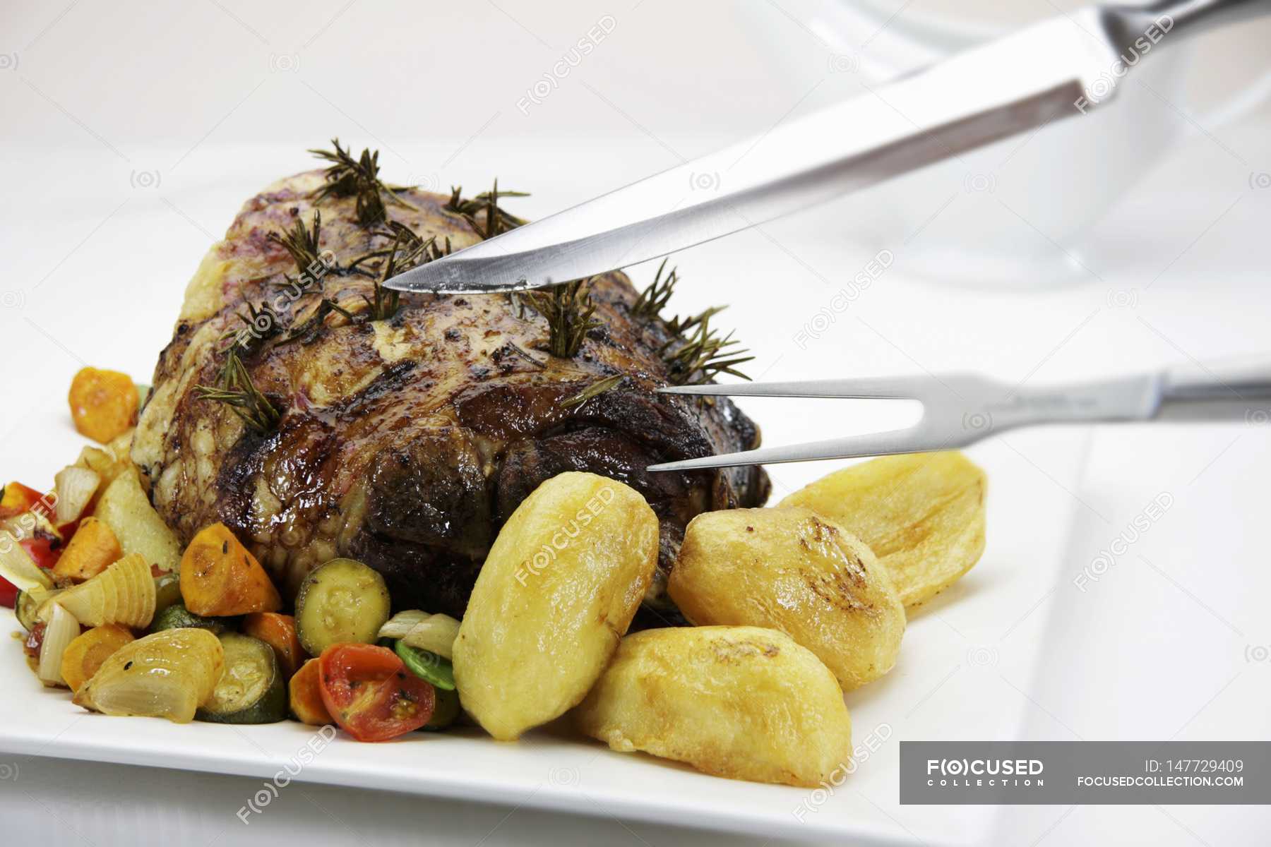 Roasted leg of lamb with baked potatoes — dish, crops - Stock Photo
